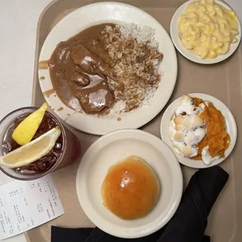 To-go style tray of roast beef and gravy over rice, mac and cheese and sweet potato casserole