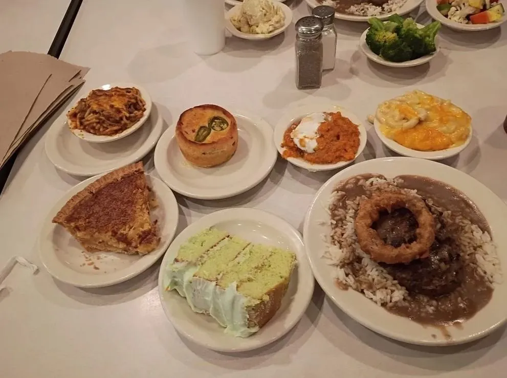 C&H Cafeteria plates of baked spaghetti, jalapeño cornbread, sweet potatoes, mac and cheese, chess pie, layer cake and hamburger steak with onion ring